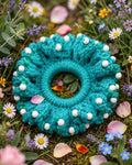 Coletero crochet turquesa con perlas blancas entre flores - LIA.G